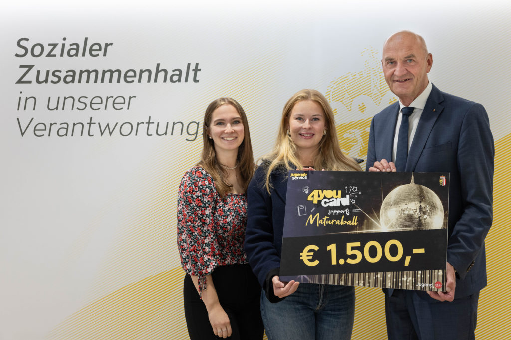 Foto (Land OÖ/Spenlingwimmer): Übergabe des Hauptpreises: Jugend-Landesrat Christian Dörfel überreicht den Hauptgewinn an die Ballleitung der HAK Wels Anna Raxendorfer und Lena Atzlesberger.